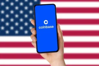 Logo de Coinbase en un smartphone frente a la bandera de Estados Unidos.